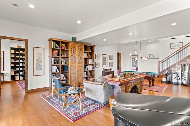 living room with hardwood / wood-style floors and billiards