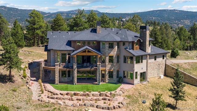 back of house featuring a yard and a mountain view