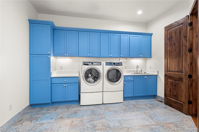 laundry area featuring cabinets, washer and dryer, and sink