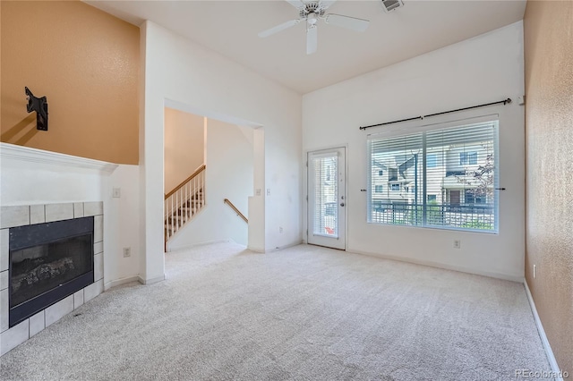 unfurnished living room featuring light carpet, a fireplace, and ceiling fan