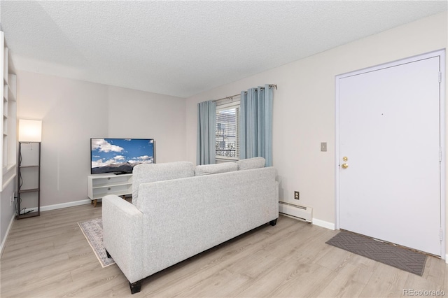 living room with light hardwood / wood-style floors, a textured ceiling, and a baseboard heating unit