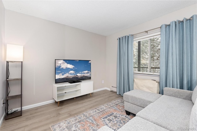 living room featuring a textured ceiling, wood-type flooring, and baseboard heating