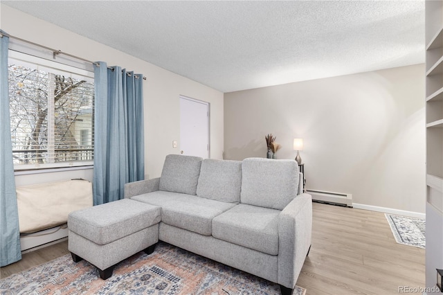 living room with a textured ceiling, light hardwood / wood-style floors, and baseboard heating