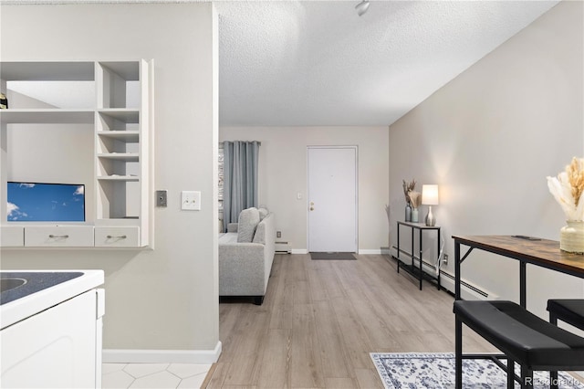 living room with a textured ceiling, light hardwood / wood-style floors, and baseboard heating