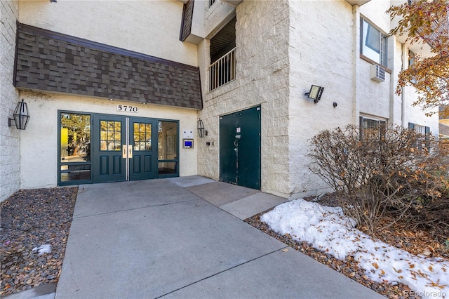 snow covered property entrance featuring french doors