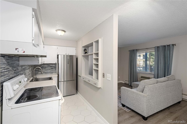 kitchen featuring sink, built in features, white range with electric cooktop, stainless steel fridge, and white cabinets