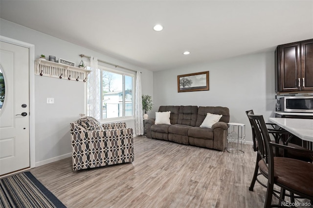 living area featuring light wood-style flooring, baseboards, and recessed lighting