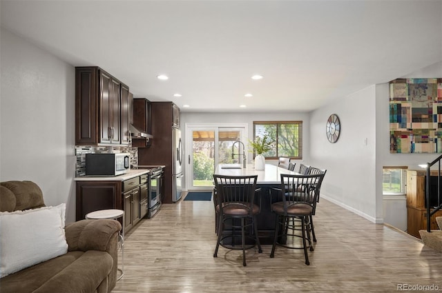 dining space with light wood finished floors, recessed lighting, and baseboards