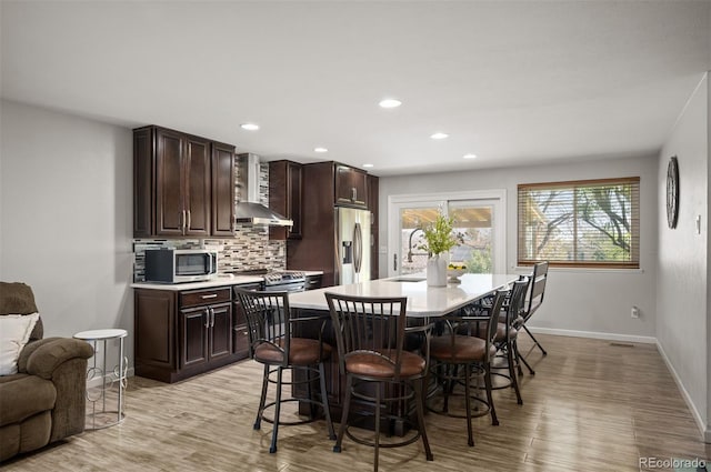dining space featuring light wood finished floors, baseboards, and recessed lighting