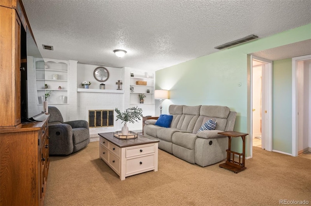 living room with light carpet, a textured ceiling, a brick fireplace, and built in features