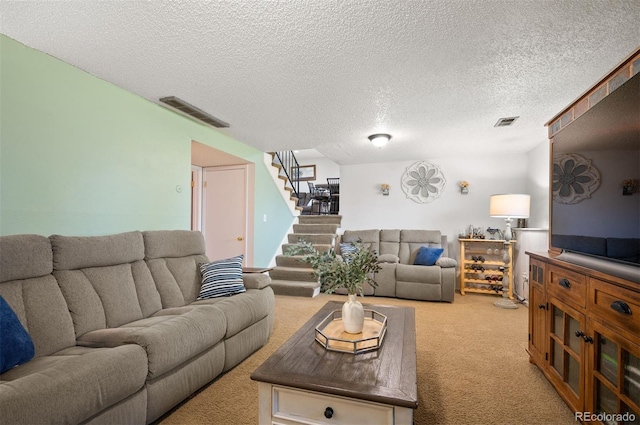 living area with light colored carpet, stairway, and a textured ceiling