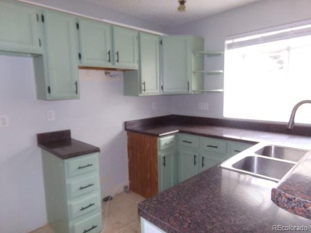 kitchen featuring dark countertops and a sink