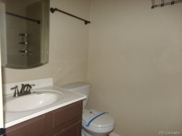 full bath featuring toilet, walk in shower, and vanity