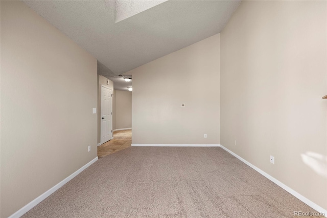 empty room with light colored carpet and a textured ceiling