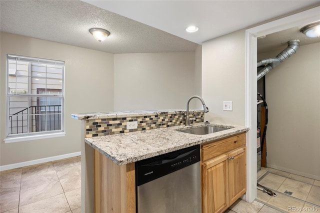 kitchen featuring light tile patterned flooring, a textured ceiling, stainless steel dishwasher, light stone counters, and sink