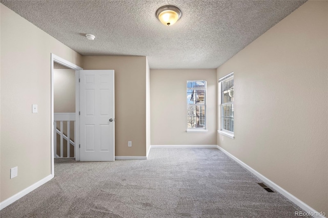 unfurnished bedroom featuring light colored carpet and a textured ceiling