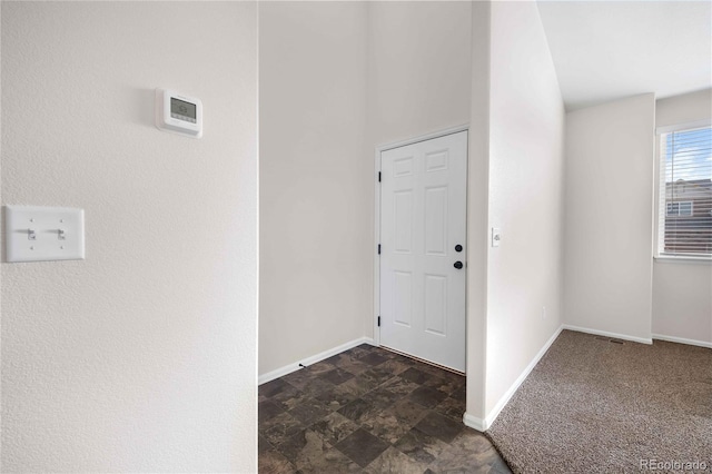 entrance foyer with dark colored carpet