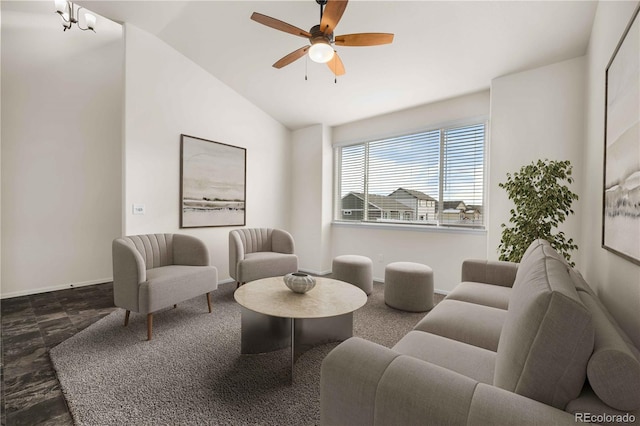 living room featuring ceiling fan with notable chandelier and vaulted ceiling