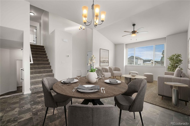 dining area featuring ceiling fan with notable chandelier and lofted ceiling