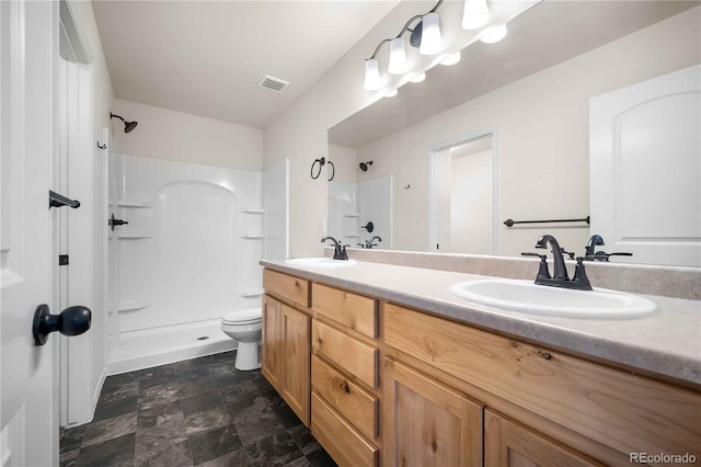 bathroom featuring toilet, vanity, and a shower