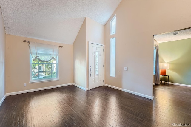 foyer entrance with a textured ceiling, high vaulted ceiling, and dark hardwood / wood-style flooring