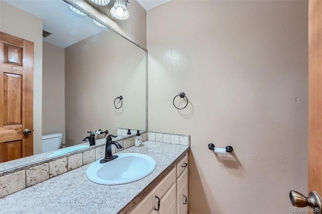 bathroom featuring vanity and toilet