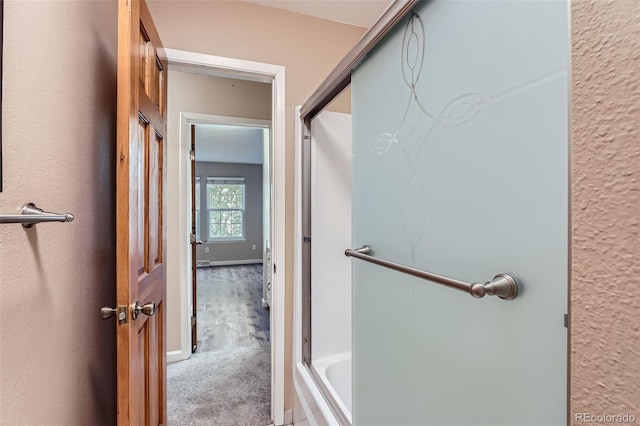 bathroom featuring combined bath / shower with glass door