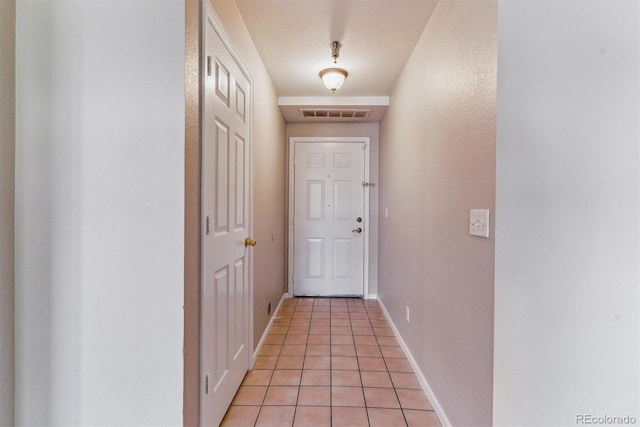 entryway featuring baseboards, light tile patterned floors, and visible vents