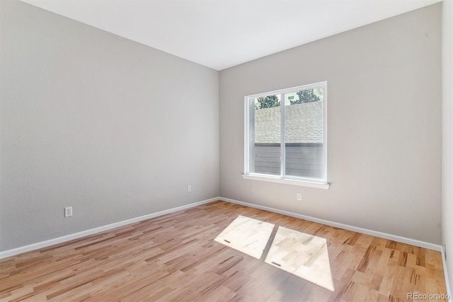 unfurnished room featuring baseboards and light wood finished floors