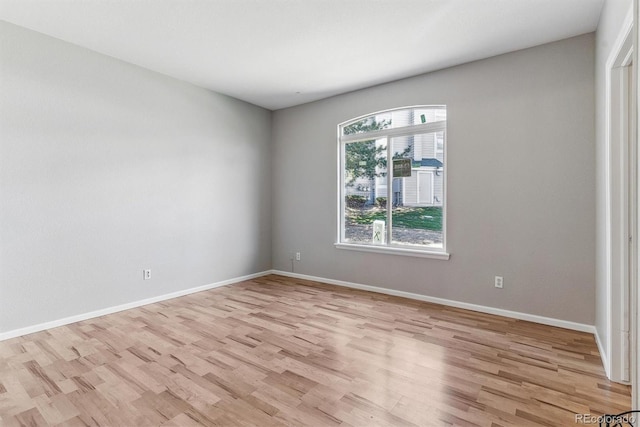 empty room with baseboards and light wood-style flooring