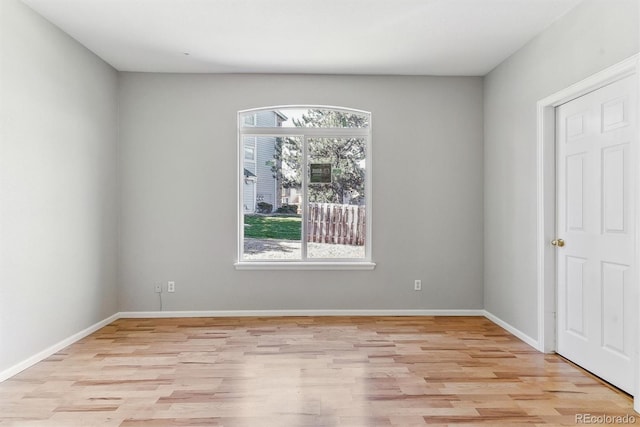spare room featuring light wood-type flooring and baseboards