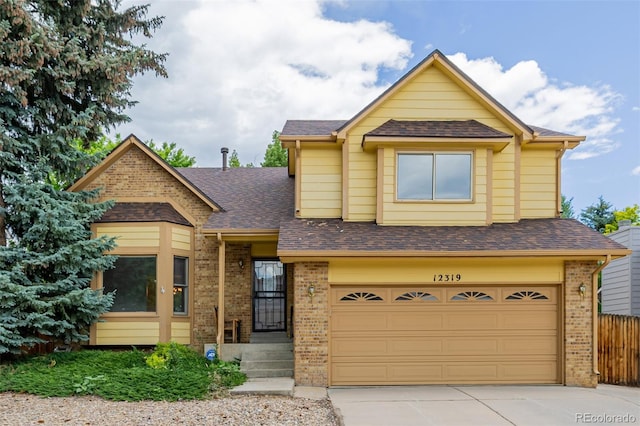 12319 W Burgundy Ave, Littleton, CO 80127 - view of front facade featuring brick siding, an attached garage, driveway, and roof with shingles