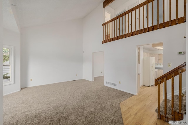 12319 W Burgundy Ave, Littleton, CO 80127 - unfurnished living room with high vaulted ceiling and light colored carpet