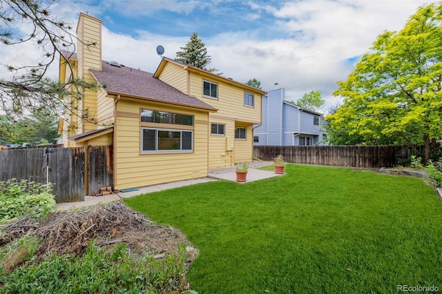 12319 W Burgundy Ave, Littleton, CO 80127 - rear view of property featuring a fenced backyard, a chimney, a patio area, and a shingled roof
