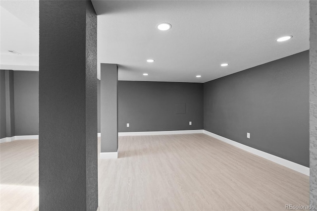 basement with light hardwood / wood-style flooring