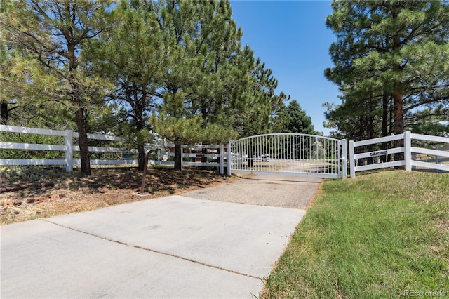 view of gate with a lawn