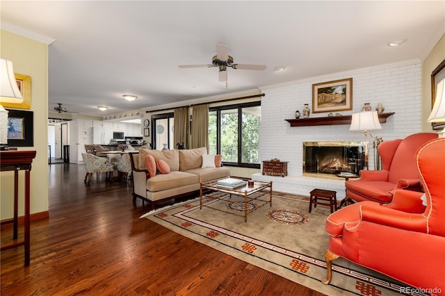 living room with ornamental molding, a fireplace, ceiling fan, and dark hardwood / wood-style floors