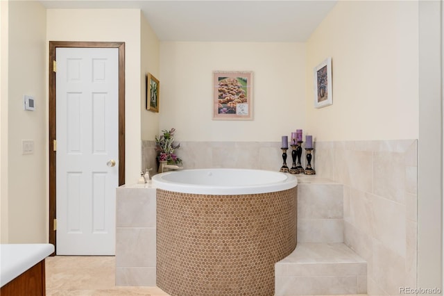 bathroom featuring tile patterned floors, vanity, and tiled bath