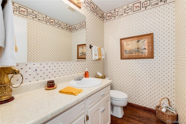 bathroom featuring vanity, wood-type flooring, and toilet