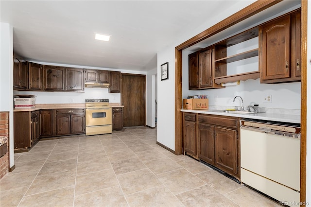 kitchen featuring light tile patterned flooring, sink, white appliances, and dark brown cabinets