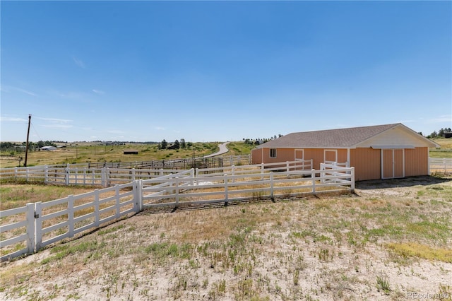 view of yard featuring an outdoor structure and a rural view