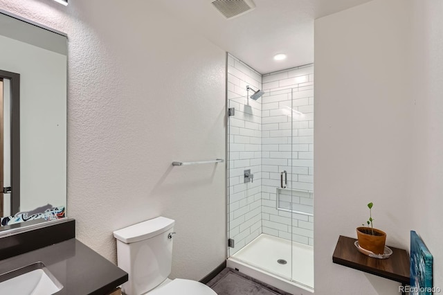 bathroom featuring vanity, toilet, and a shower with door