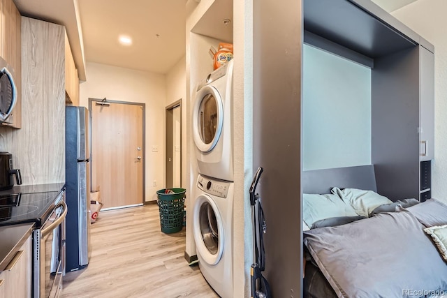 washroom with stacked washer / drying machine and light wood-type flooring