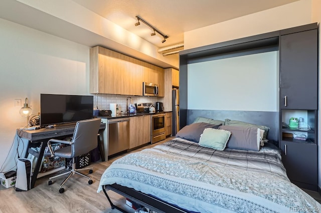 bedroom featuring light wood-type flooring and track lighting