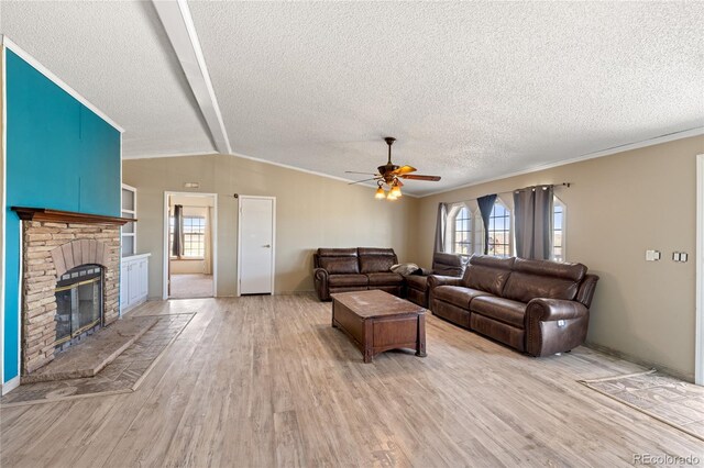 24655 2nd Ave, Eaton, CO 80615 - living room with light wood-style floors, a ceiling fan, a textured ceiling, a glass covered fireplace, and crown molding