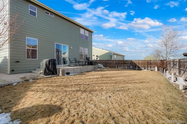 rear view of house with a lawn, a patio area, and a fenced backyard