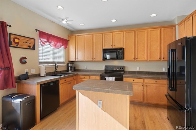 kitchen featuring black appliances, tile countertops, and a center island