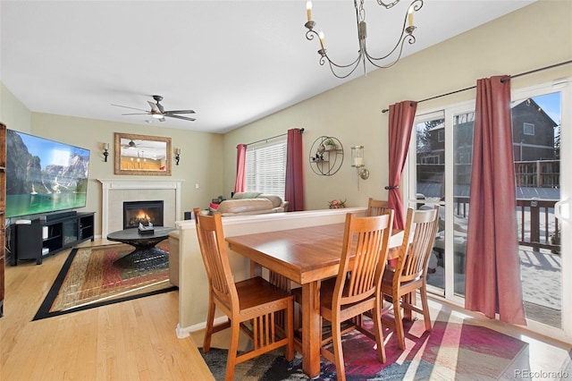 dining space featuring ceiling fan with notable chandelier and light hardwood / wood-style floors