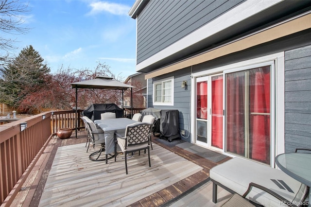 wooden terrace with a gazebo and a grill