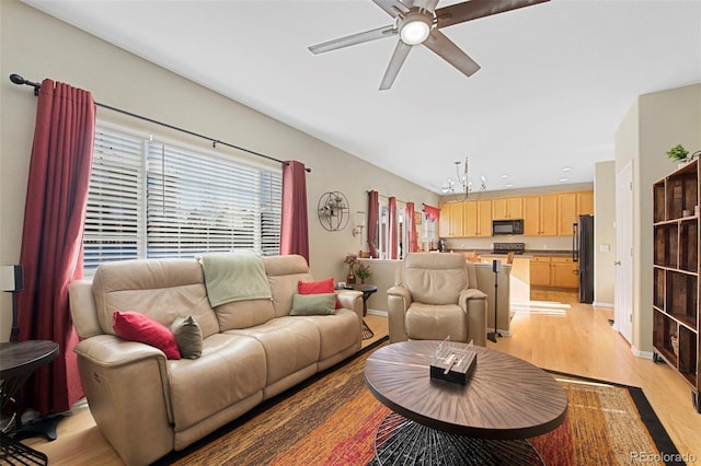 living room featuring ceiling fan and light hardwood / wood-style flooring